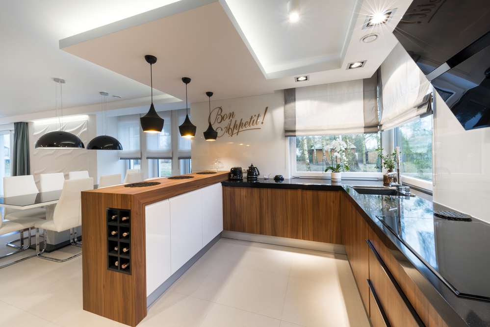 Modern kitchen illuminated with ceiling lights and pendant lights