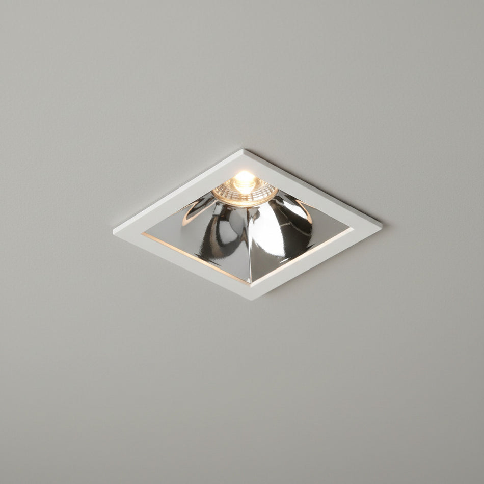 sqaure chrome downlight installed on a grey ceiling