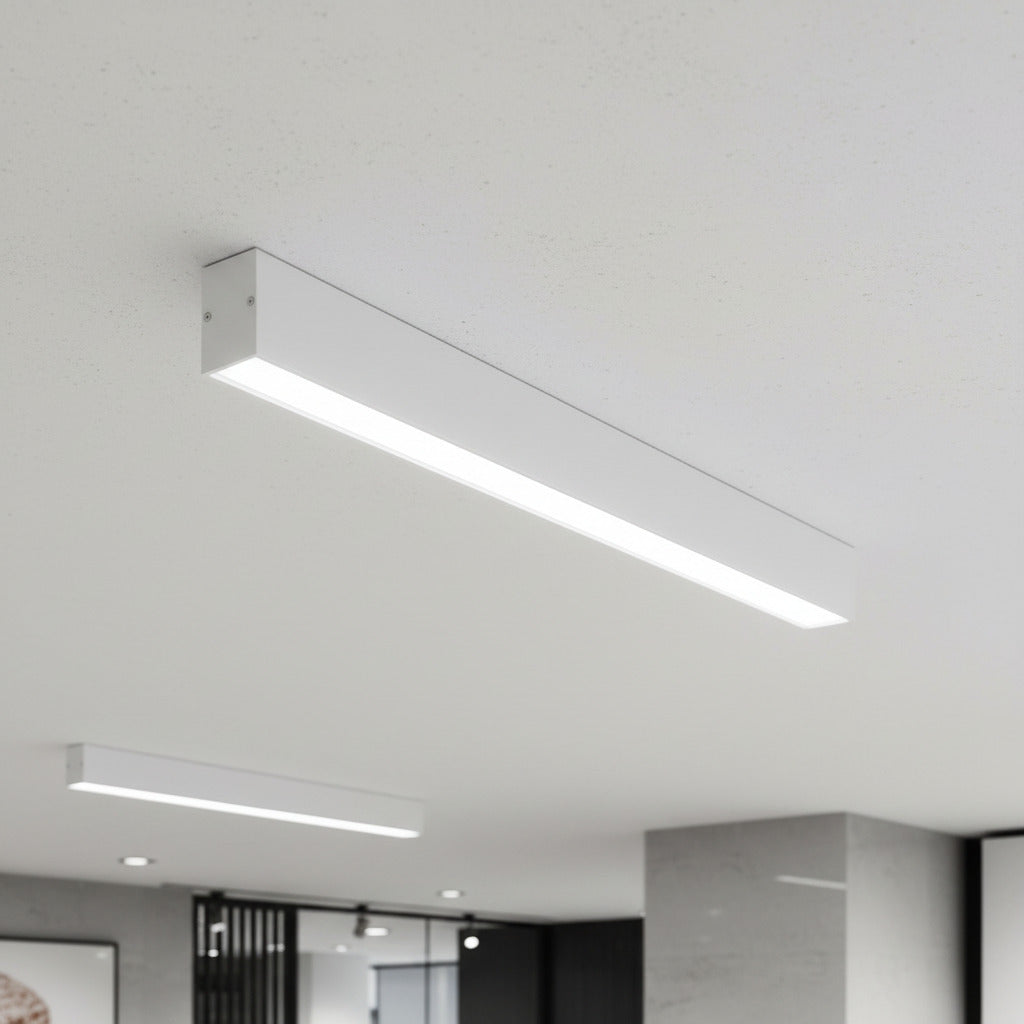 white surface mounted linear LED light mounted on a white ceiling in an office