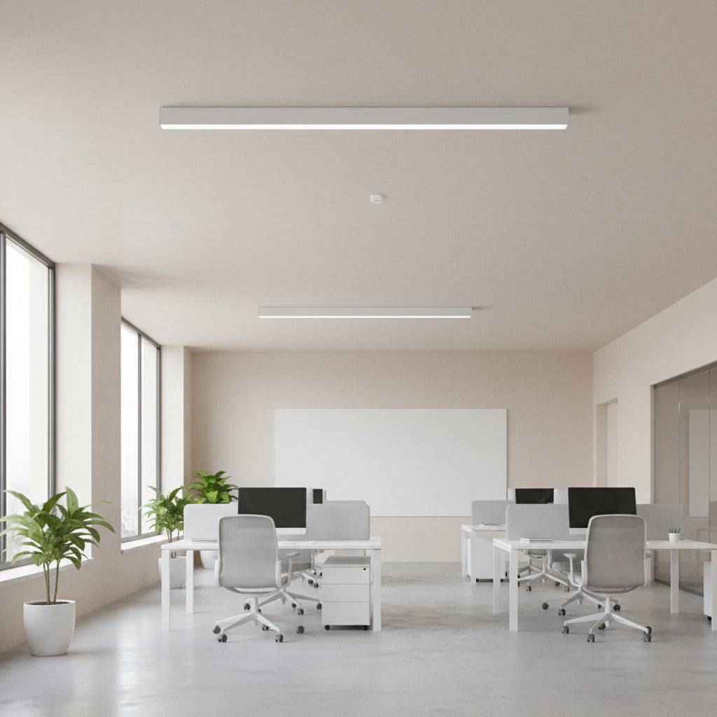 white linear surface mounted light fitted on the ceiling in an office 