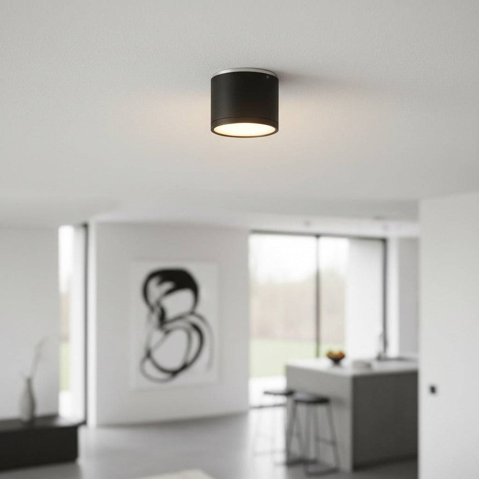 black round surface downlight mounted on the ceiling in a modern home