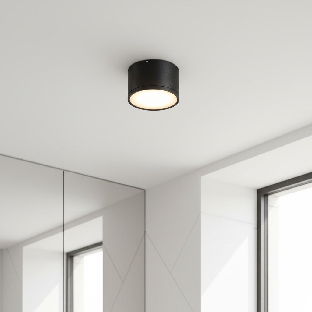 black round LED surface mount light mounted on a white ceiling in a home