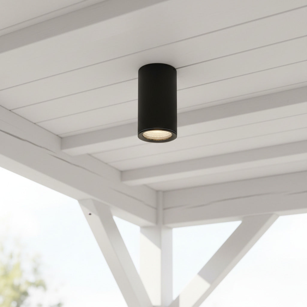 black surface mounted soffit light mounted under an outdoor porch area