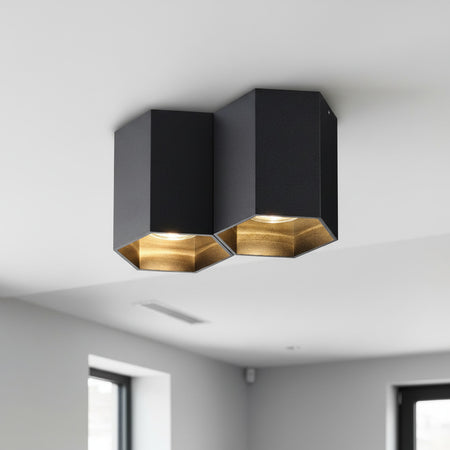 black surface ceiling spotlight mounted on a white ceiling in a home