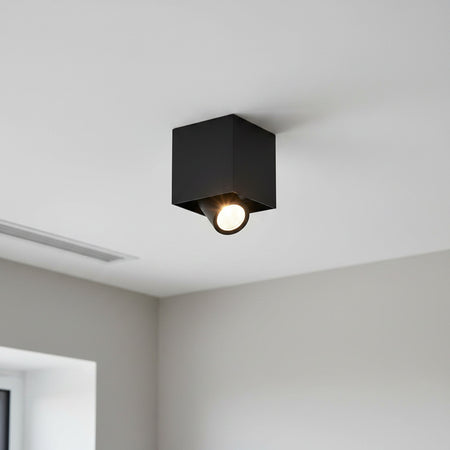 adjustable black surface downlight mounted in a white ceiling 