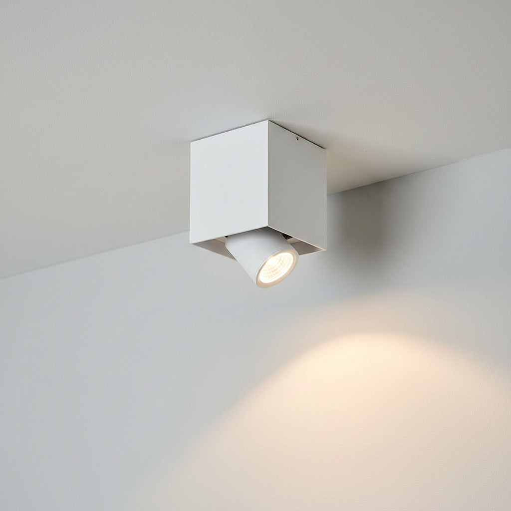 white surface mounted ceiling downlight mounted on a white ceiling next to a wall 
