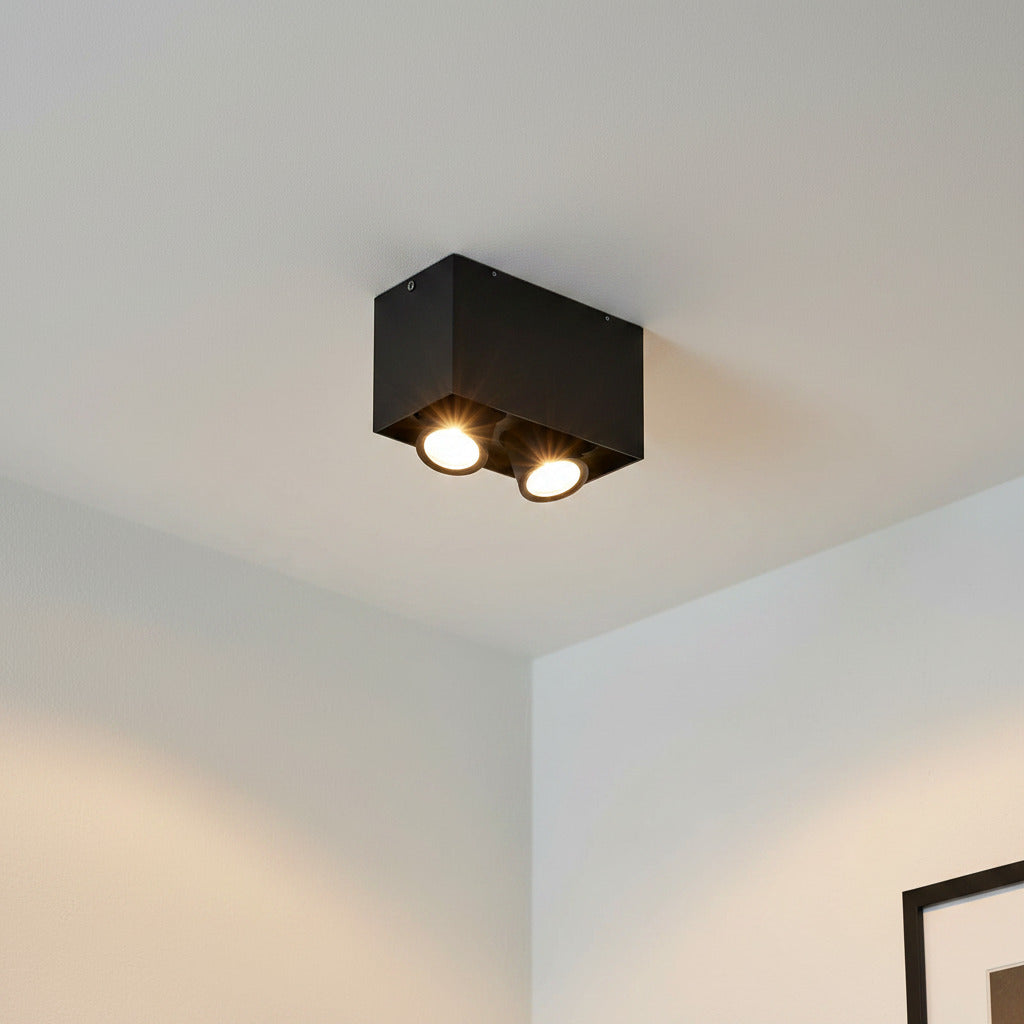 black adjustable LED surface down light mounted on a white ceiling 