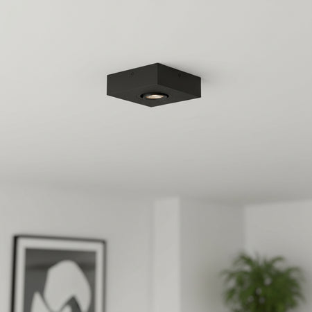black slimline surface ceiling downlight mounted on the ceiling in a modern house