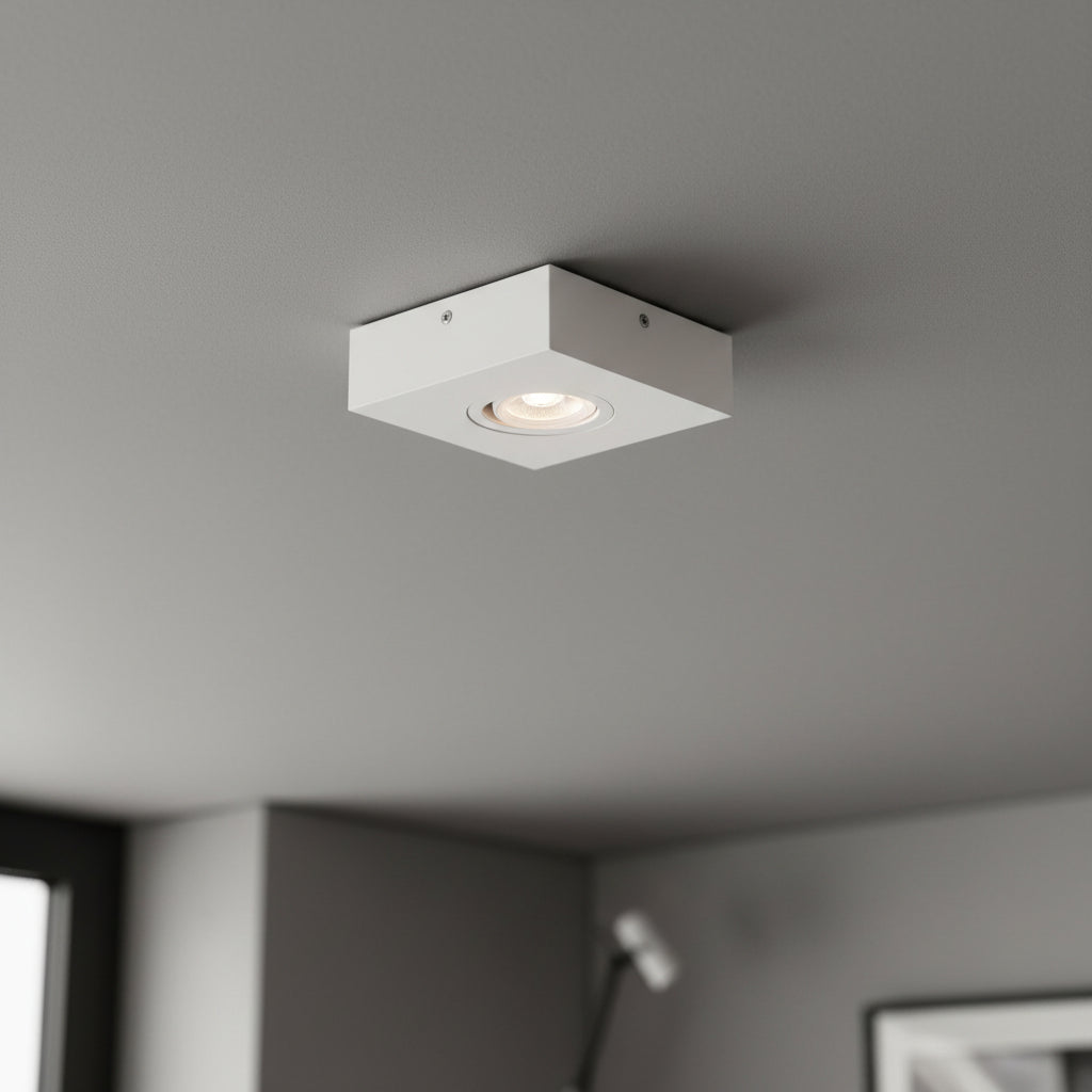 white low profile surface mount downlight installed on a grey ceiling 