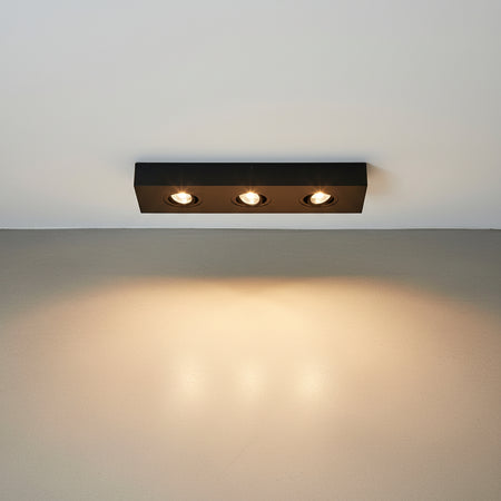 black surface mounted downlight installed on a white ceiling