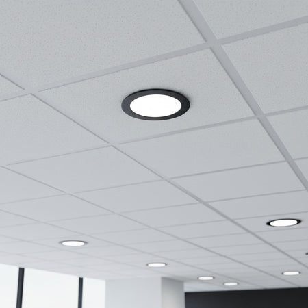black low profile downlight installed into a suspended ceiling in an office