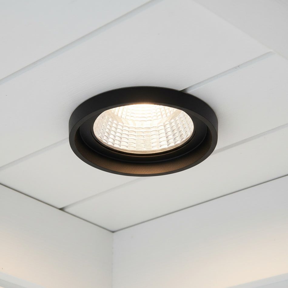 black exterior downlight mounted on the white ceiling on the exterior of a home