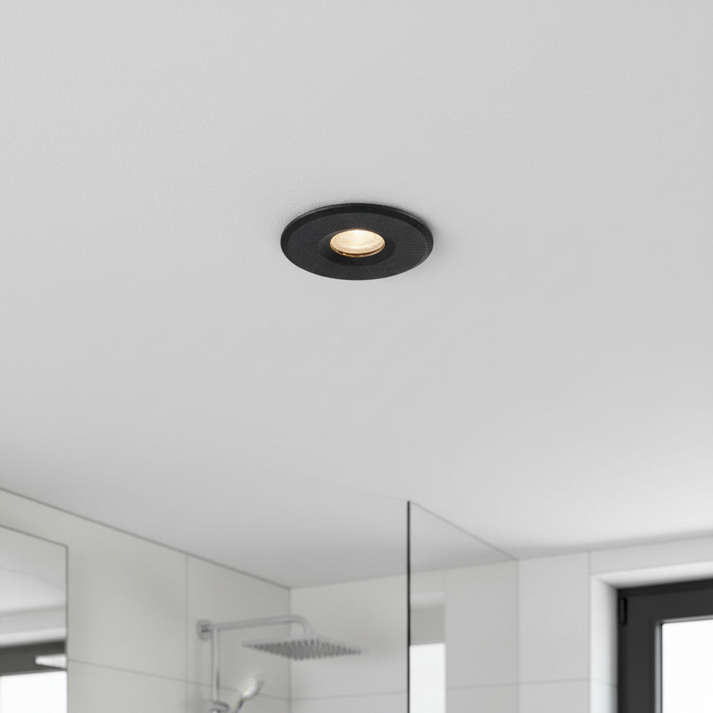 black waterproof recessed bathroom ceiling light installed on the ceiling in a bathroom 