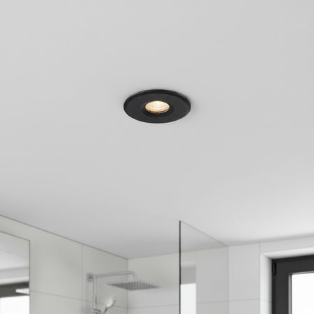 black waterproof recessed bathroom ceiling light installed on the ceiling in a bathroom 