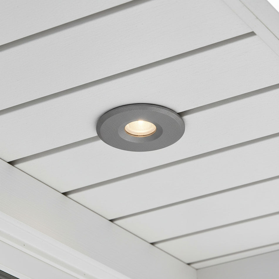 grey small soffit light mounted in a white house soffit 