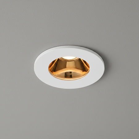 white and gold recessed ceiling downlight on a grey ceiling 