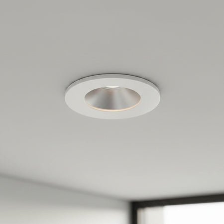 white recessed ceiling mounted downlight mounted on a grey ceiling 