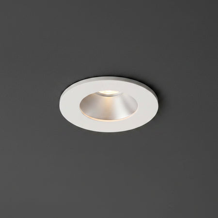 white recessed ceiling mounted downlight installed on a dark grey ceiling 