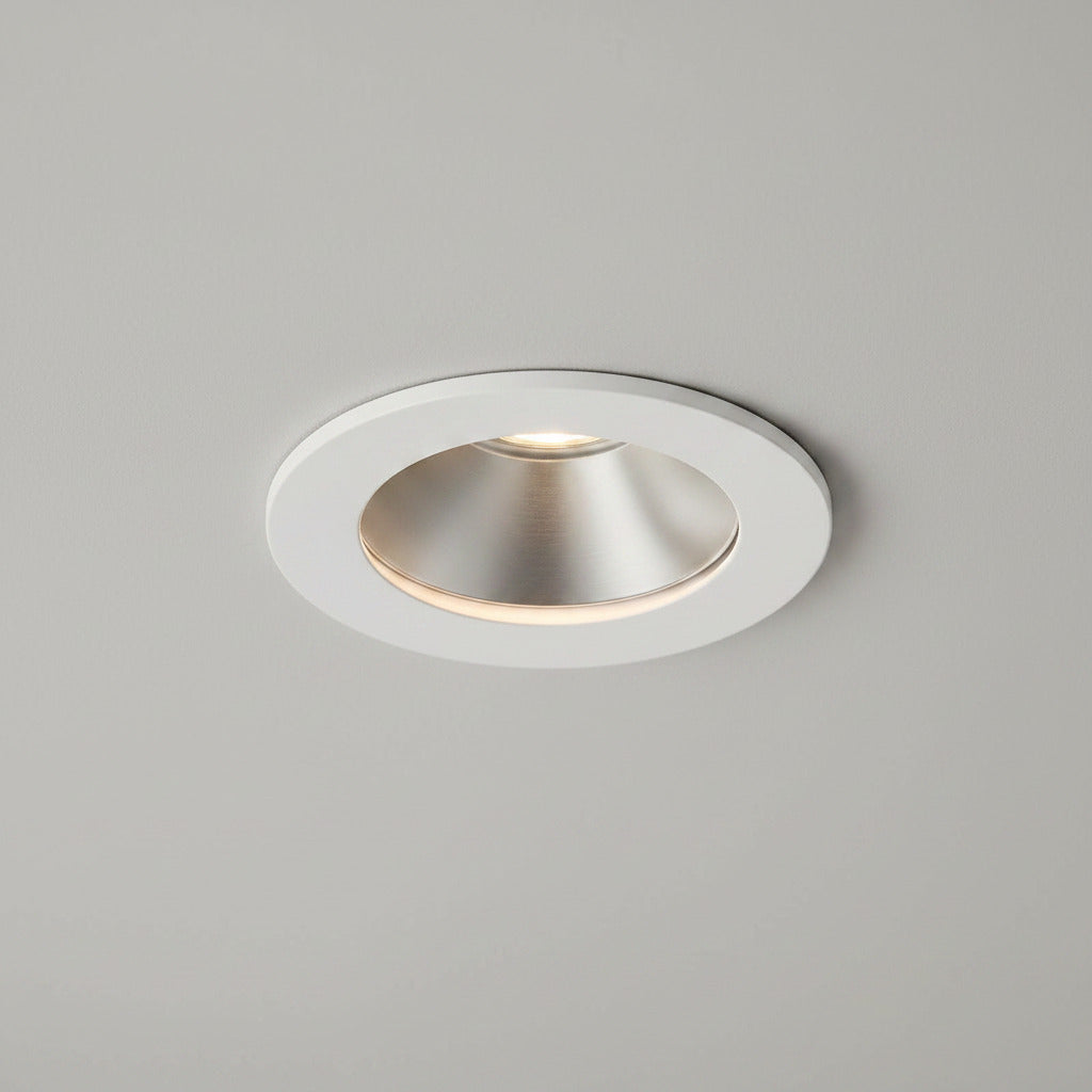 white recessed LED downlight fitting on a light grey ceiling 