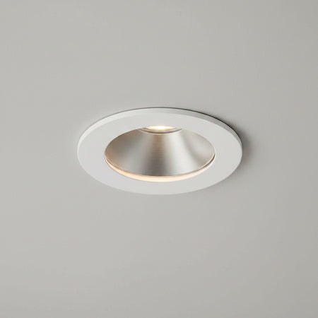 white recessed LED downlight fitting on a light grey ceiling 
