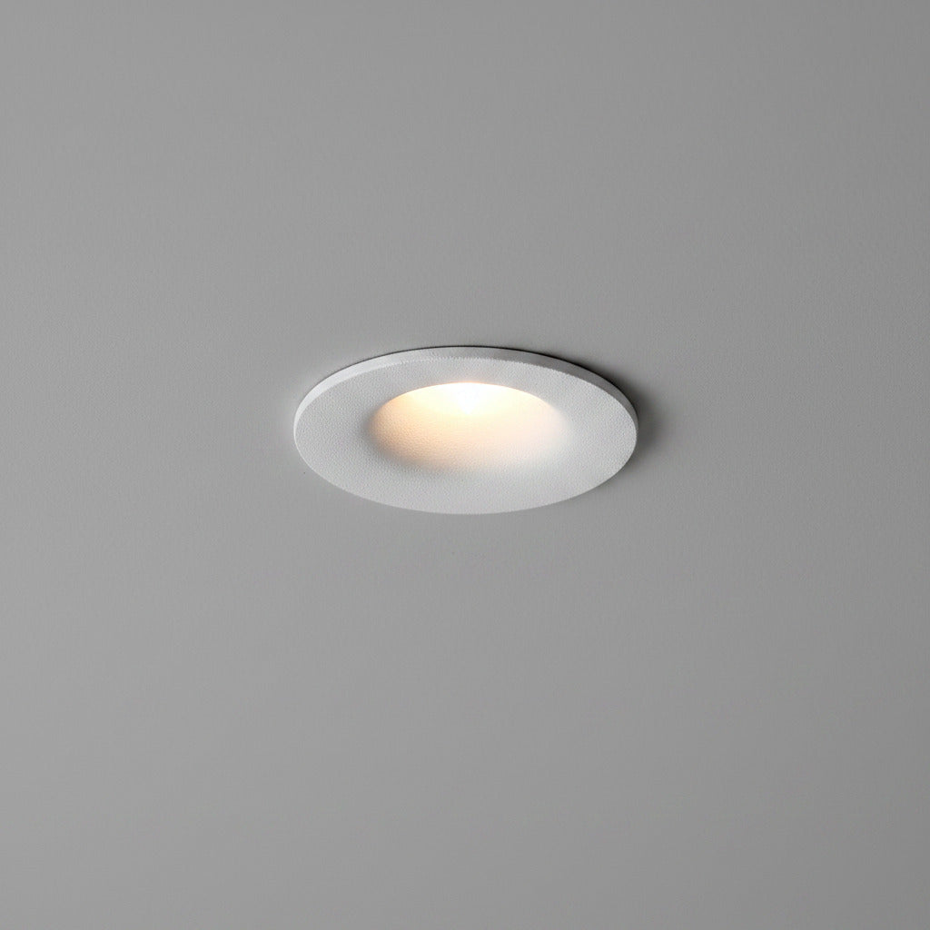white small LED downlight fitting installed on a light grey ceiling 