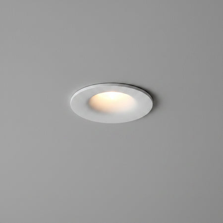 white small LED downlight fitting installed on a light grey ceiling 