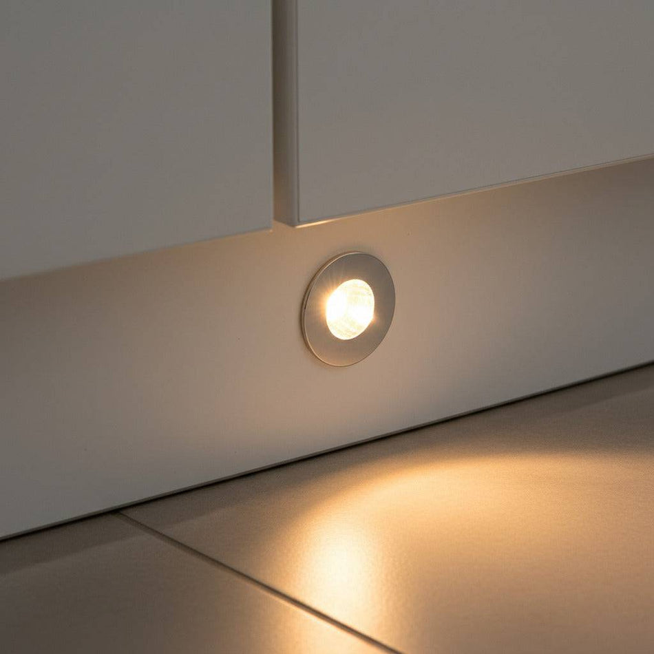 chrome led plinth light shown mounted in a white low level kitchen plinth 