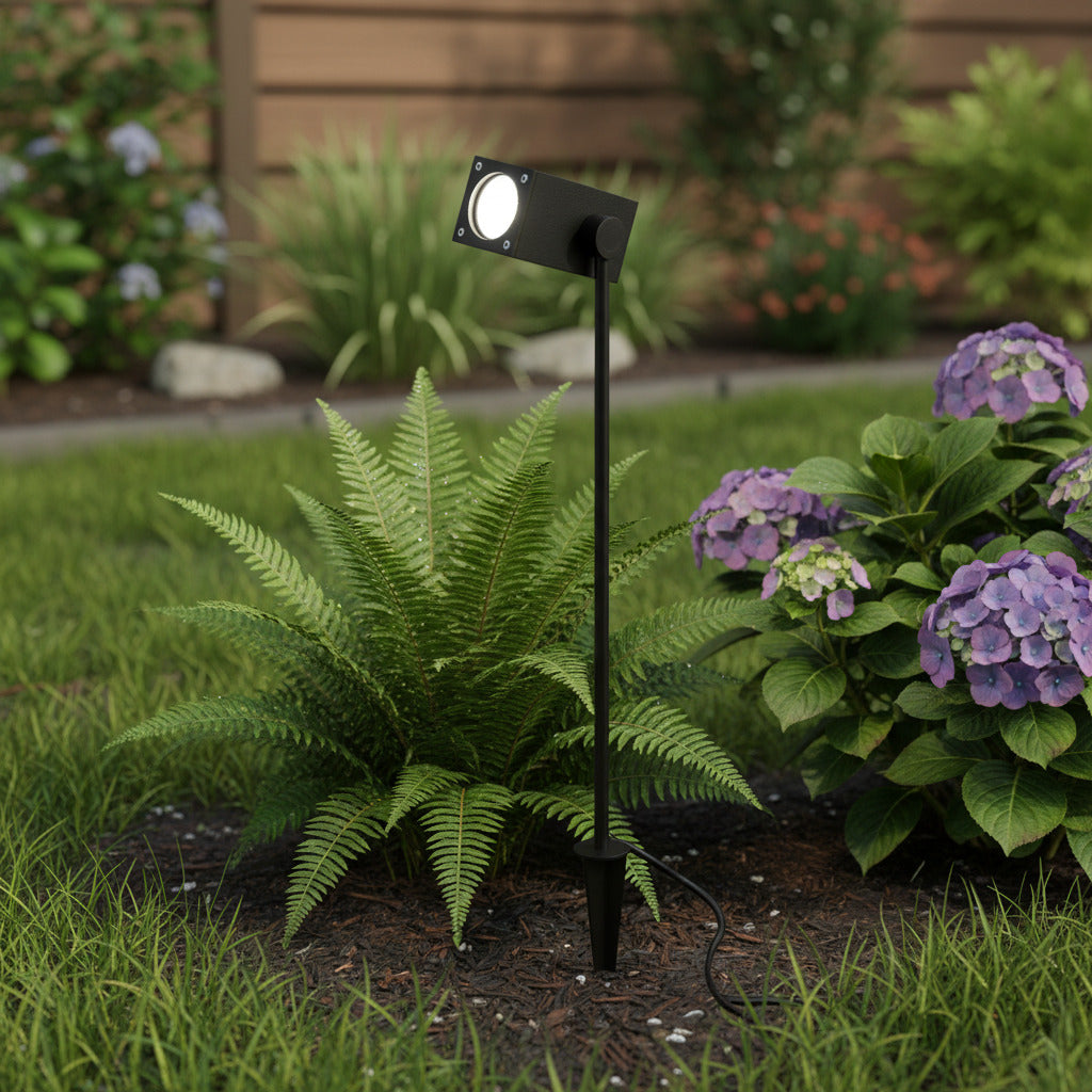 black IP65 garden spike light mounted in front of plants in a garden border 