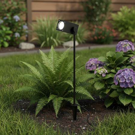 black IP65 garden spike light mounted in front of plants in a garden border 