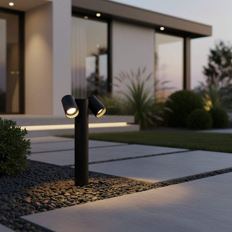 black adjustable bollard light mounted in a stone garden border 