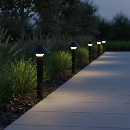 Black garden bollard light fixture on a straight grey pathway 