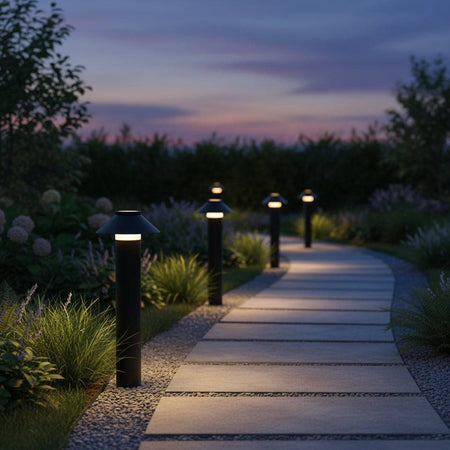 Black landscape bollard lights on curved pathway at sunset