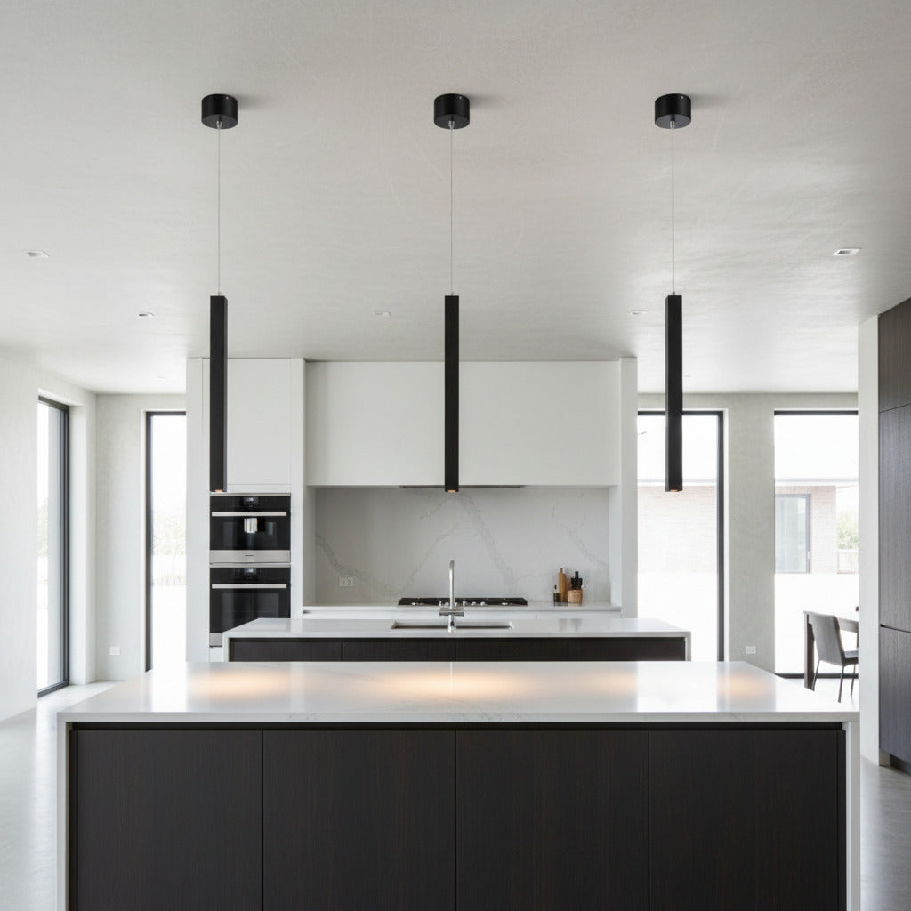 black slimline hanging pendant light mounted in a row over a kitchen island 