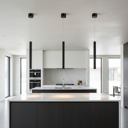 black slimline hanging pendant light mounted in a row over a kitchen island 