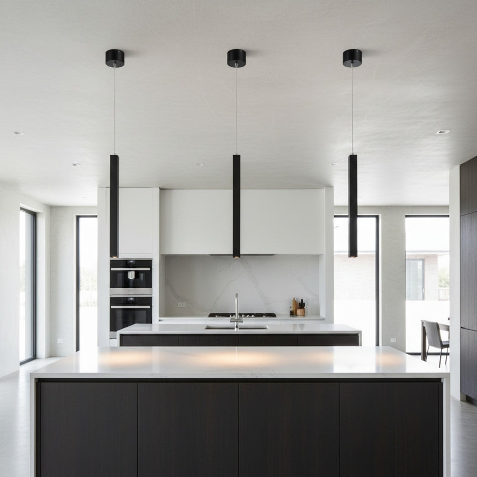 black slimline hanging pendant light mounted in a row over a kitchen island 