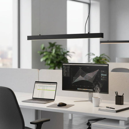 Black hanging bar light above a workstation in an office 