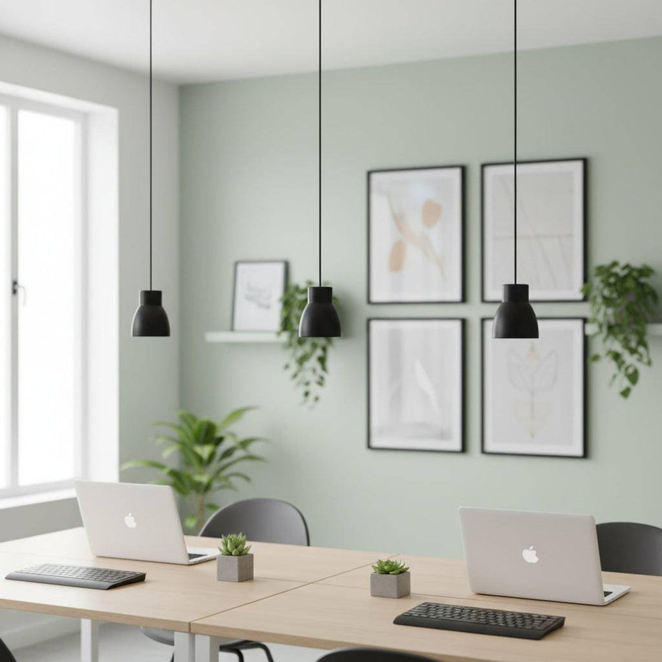 Black LED pendant light three above desks with laptops on them in a modern setting