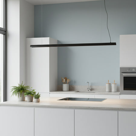 Black linear pendant light in a kitchen above a work station with plants against a pale blue background