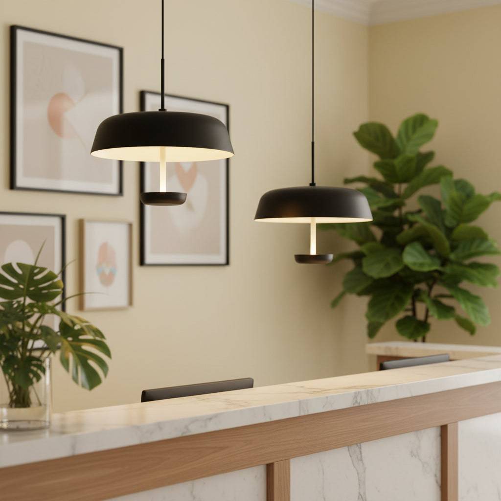 Metal pendant light on a pale yellow background of a hotel reception.