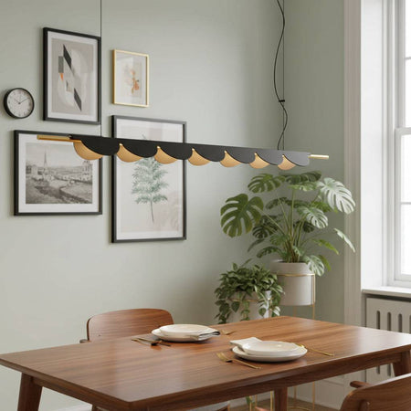 Black linear pendant lamp above a dining room table with plants and pictures