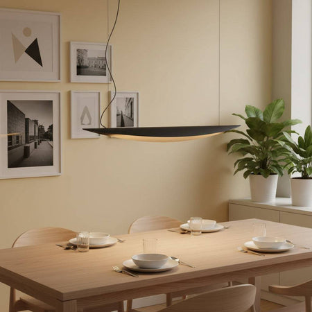 Linear pendant light on a pale yellow background above a pine dining room table with  cutlery and chins