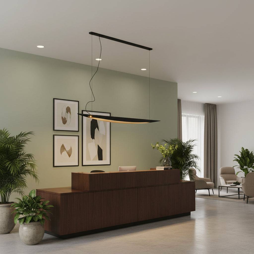 Linear pendant light above a hotel reception desk with plants and furniture