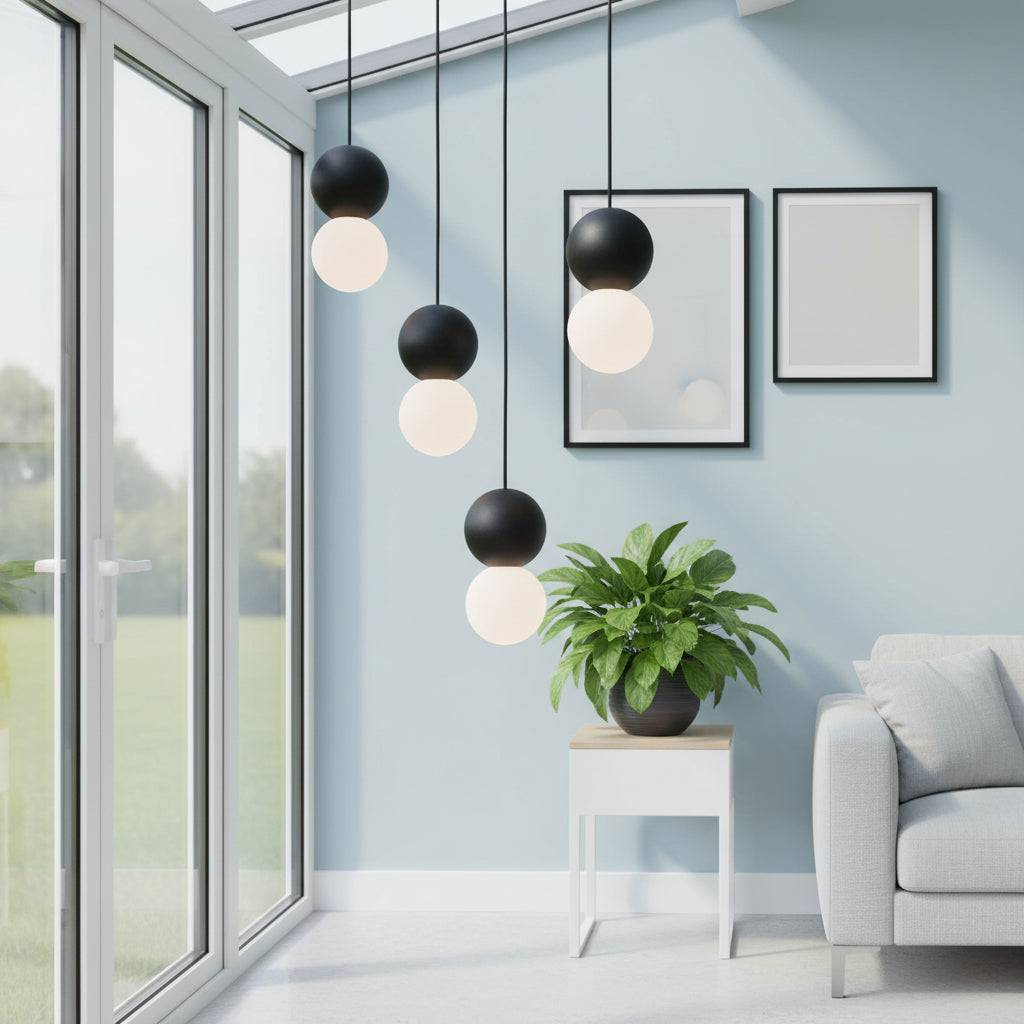 Black globe pendant light in a modern conservatory with plant and furniture