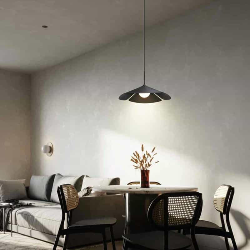 Black ceiling pendant light above a table and chairs on a grey background