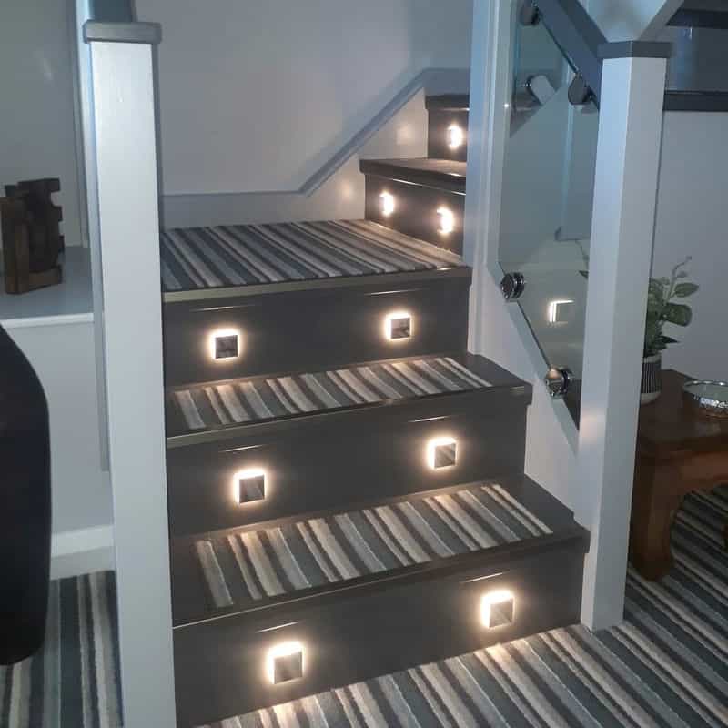 mini interior step light installed on a carpeted stairway