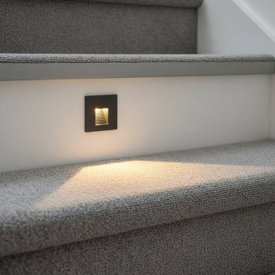 black motion sensor light for stairs installed into a home stair riser