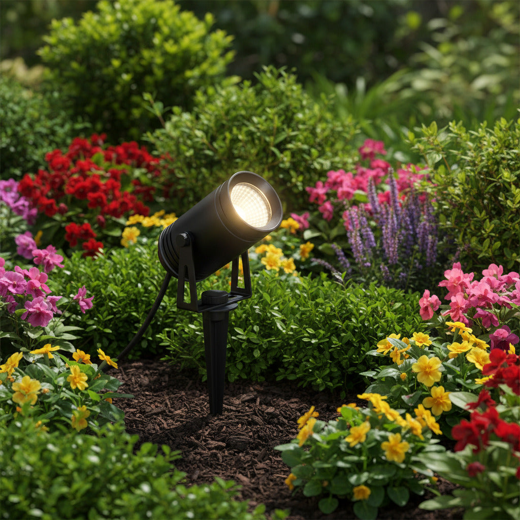 black LED stake light installed in a garden border