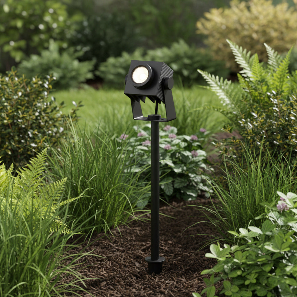 black garden stake light spiked into a garden border around plants 