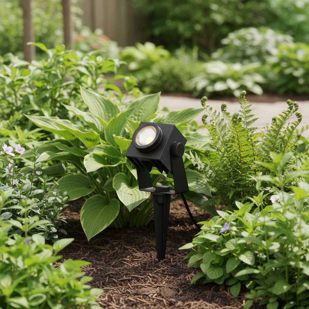black LED garden stake light spiked into a garden border