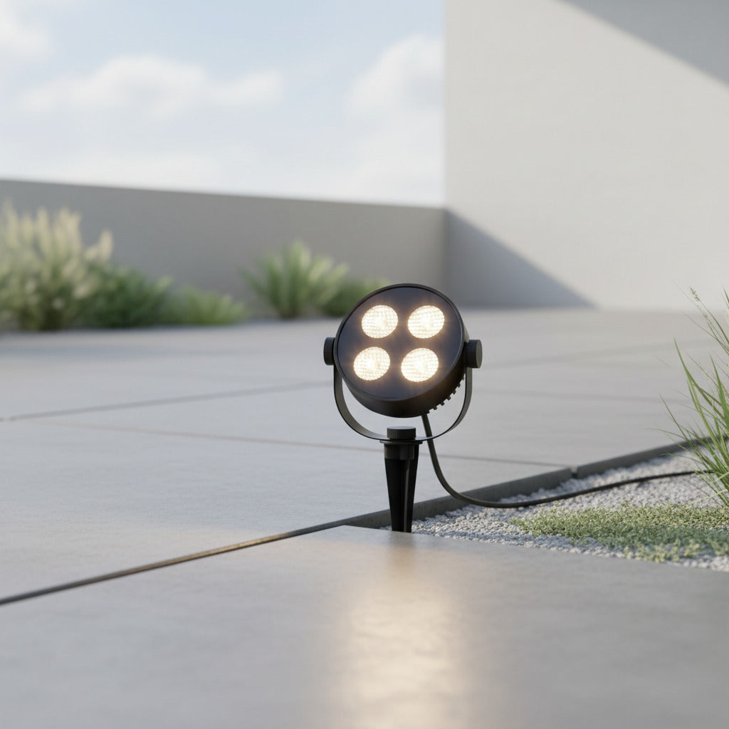 black electric garden spike light installed next to a pathway 